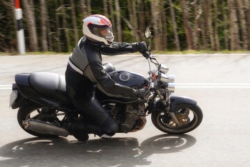 Motorradfahrer auf einer Landstrasse in einer Kurve beim dynamischen fahren