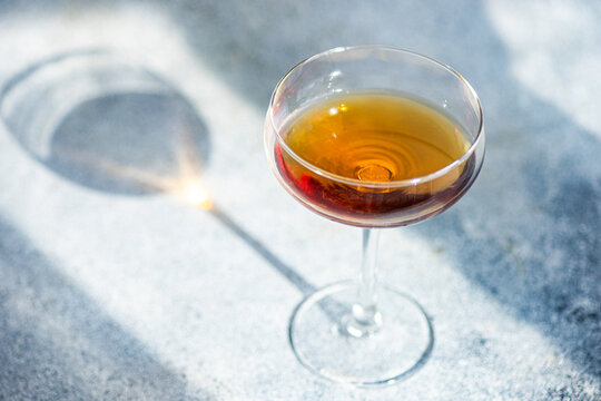 Close-up of a Glass of Georgian amber wine and its shadow on a table