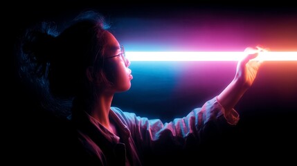 Fototapeta premium Young person experiences light art in dark setting while creating a unique visual display