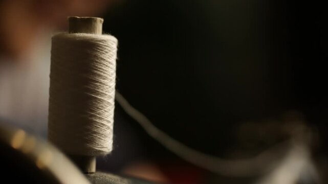 A skein of white thread on a sewing machine, close-up view