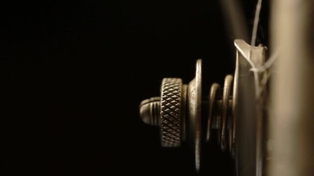 An old sewing machine sews fabric, the metal part of the machine