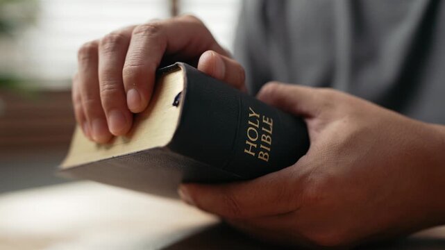 Hands clasped prayer with Holy Bible for Christian faith, spirituality, worship, devotion, hope, and religious belief, prayer time in church, trust in God, and spiritual guidance.