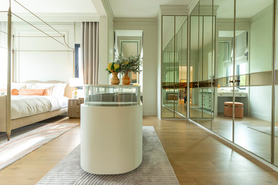 Luxury modern walk-in closet with mirror cabinets facades and island console.
