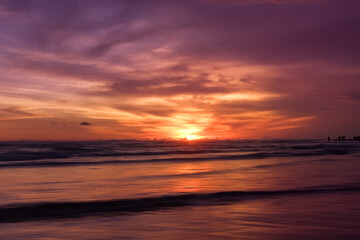 Obraz premium Dramatic colorful sunset seascape at Parangtritis Beach, Yogyakarta with ocean waves and silhouettes