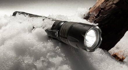 Rechargeable flashlight on and in freezing winter snow