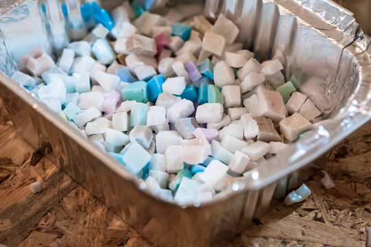 Primo pianori una vaschetta di alluminio contenente colorate tessere di un futuro mosaico