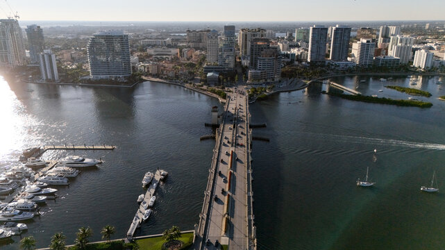 Aerial view of coastal city bridge marina and waterfront skyline at sunset