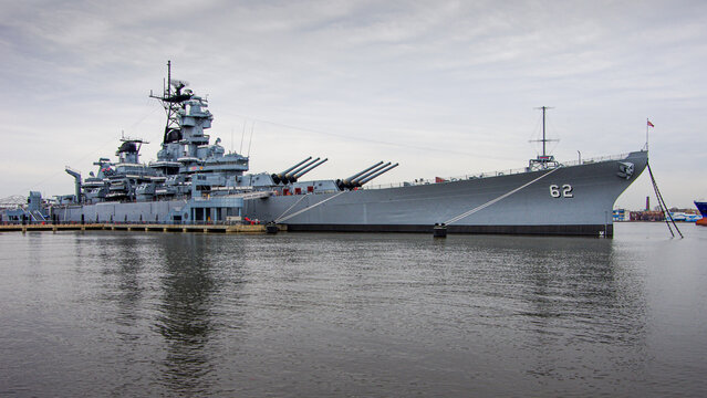 Camden, NJ&mdash;Mar. 1, 2018; The Battleship New Jersey (BB-62), a historic Iowa-class U.S. Navy battleship, sits moored in Camden as a museum ship under an overcast winter sky.