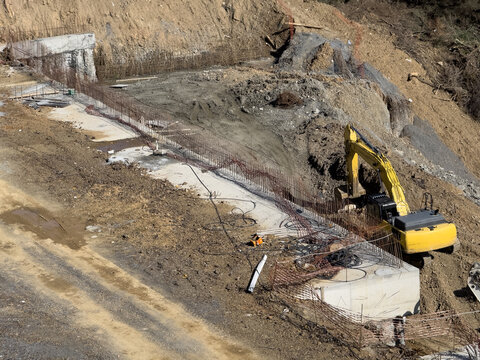 View of the construction site with the yellow excavator and concrete structures under a sunny sky, Istanbul, Istanbul, Turkey.