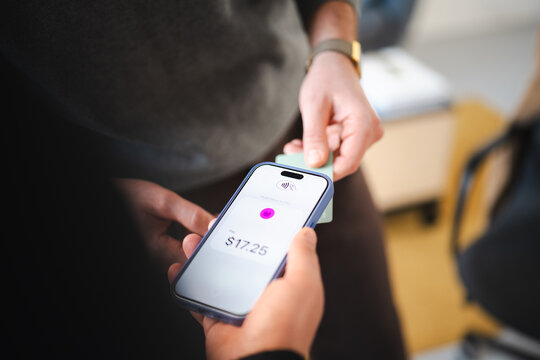 A person uses a mobile device to make a contactless payment for a purchase of seventeen dollars and twenty-five cents.