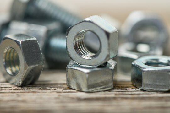 Close-up of M8 bolts and nuts on old wooden table