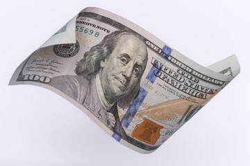 Single 100 US Dollar Bill Flying over Light Background