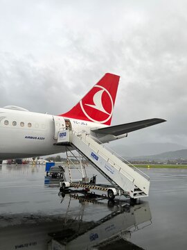 Tail section of a Turkish Airlines Airbus A321 aircraft with boarding stairs attached on the wet tarmac at Batumi International Airport, Georgia, 2023