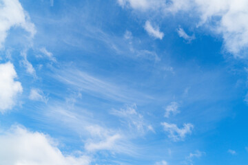 Fototapeta premium Bright blue sky with white clouds over a natural landscape during a sunny day