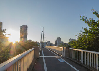 夕日に照らされる川沿いの歩行者専用橋
