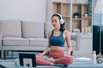 Young Asian sporty attractive people practicing yoga lesson with instructor. Asia group of women exercising healthy lifestyle in fitness studio. Sport activity, gymnastics or ballet dancing class.