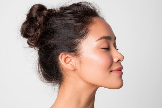 A tranquil and close-up profile captures a woman with her eyes gently closed, radiating a sense of peacefulness and serenity. Her healthy, glowing skin is highlighted by soft, natural light, emphasizi
