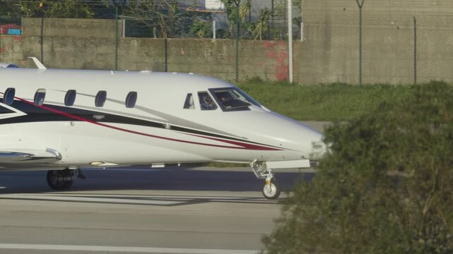Private business jet taxiing on airport runway