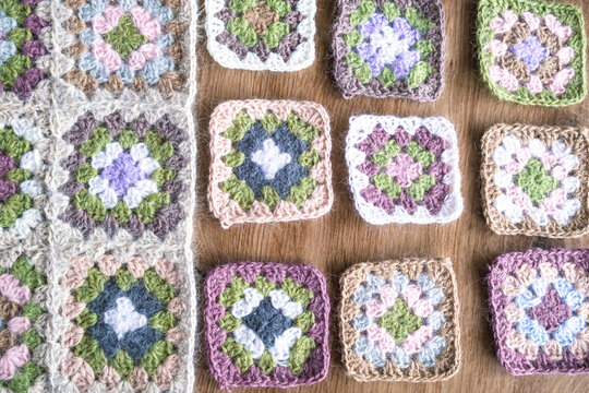 Work in progress crochet project with granny squares partially assembled. Handmade patchwork process and creative routine concept. Craft process, handmade fashion creation and slow creative lifestyle 