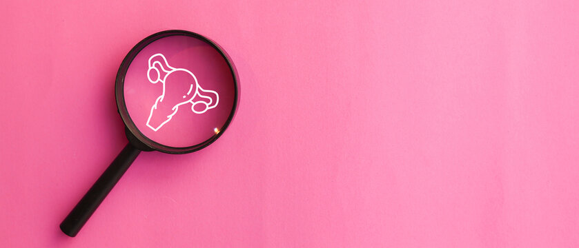 close up top view on magnify with uterus symbol on pink background represent about women health checkup and lifestyle for health and wellness concept