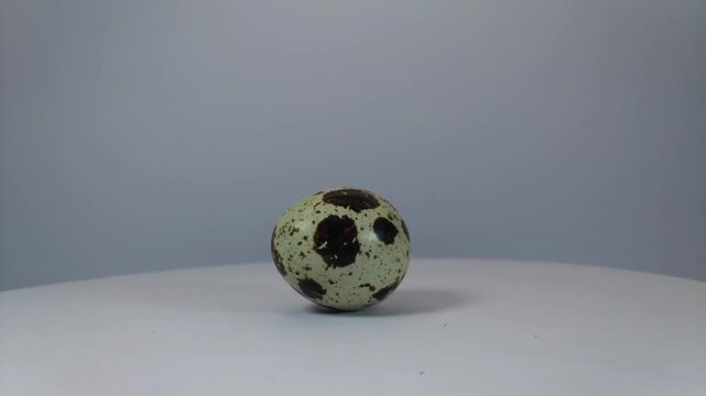 Whole quail eggs with shell, with distinctive and different patterned ornaments, rotating.