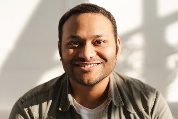 Obraz premium Portrait of handsome man looking at camera sitting on comfortable sofa in living room at home