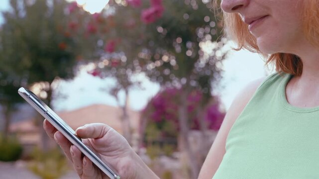 Female in Residential Cottage Community Using Smartphone Outdoors for Searching Data and Communication