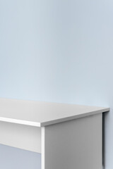 White desk against blue wall with copy space
