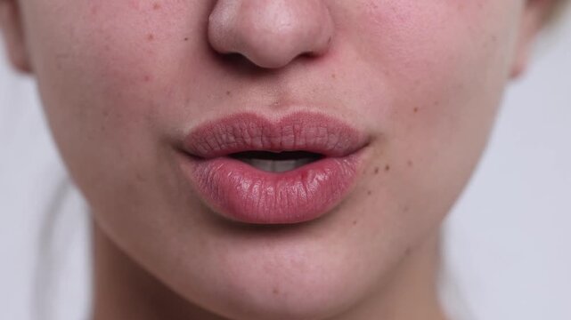 4K video macro closeup of young woman lips serious to smile, mouthing I love you and licking lips, no makeup and natural look