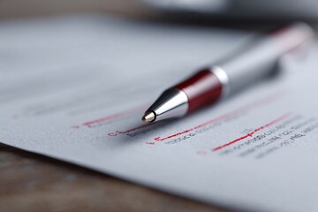 Red pen marking corrections on printed document closeup