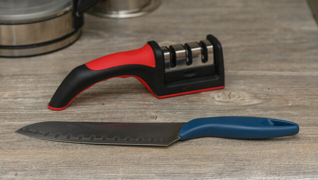 Kitchen Knife in Sharpener on the Table