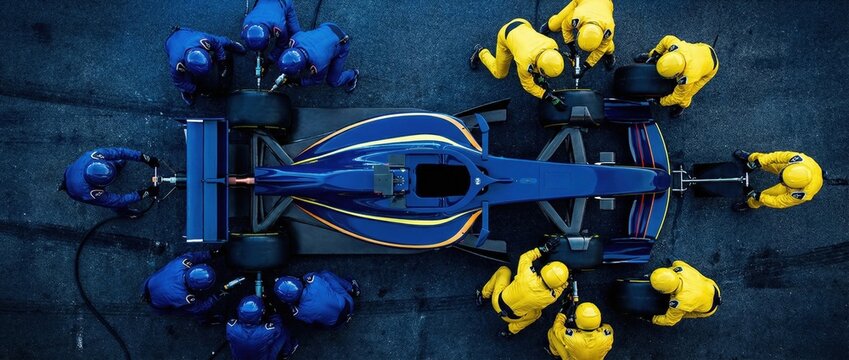 Aerial top view blue and yellow formula race car pit stop action. Concept of competitive racing broadcast visuals, brand sponsorship activation, high performance team dynamics. Banner