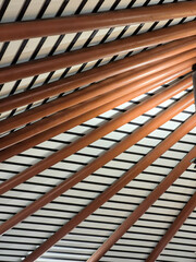 Obraz premium abstract architectural detail of modern ceiling with brown pipes and Parallels line patterns. background