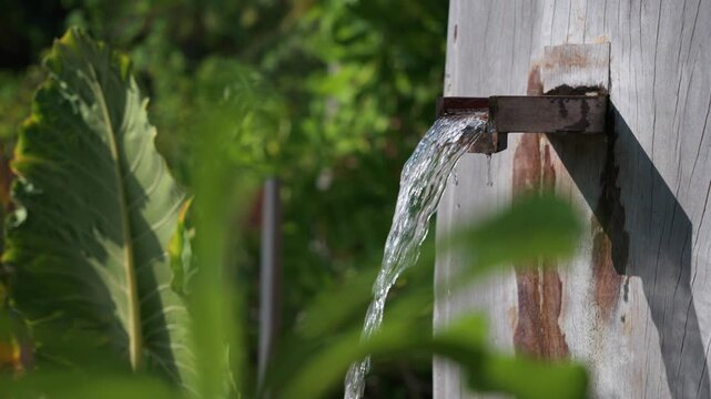 Rustic metal spout pouring water