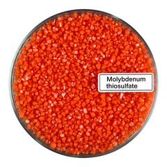 Glass bowl filled with small orange molybdenum thiosulfate crystals or granules for industrial use