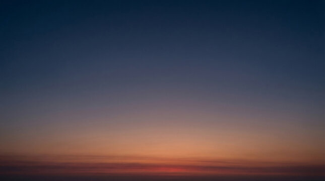 Smooth gradient sky transitioning from deep blue to warm orange and red hues capturing the serene atmosphere of dawn or dusk