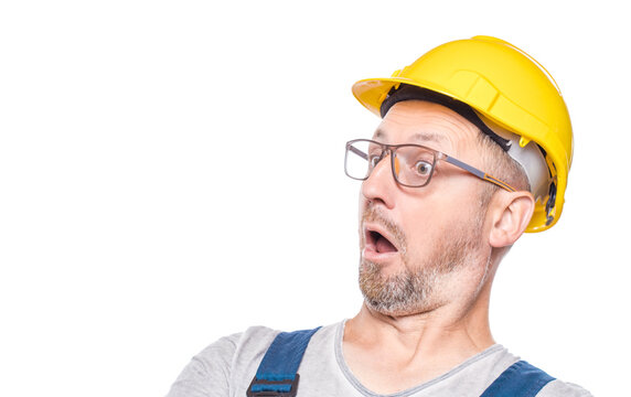 Afraid construction worker with popcorn looking to the side, isolated on white background. Scared repairman. Weekend times - movies watching concept. Craftsman against white wall
