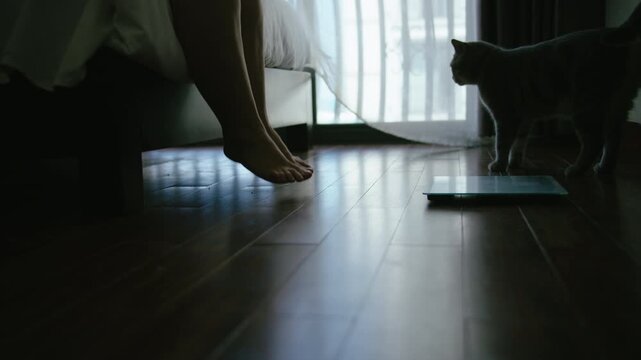 Adult Woman with Extra Weight Measuring Herself on Bathroom Scale