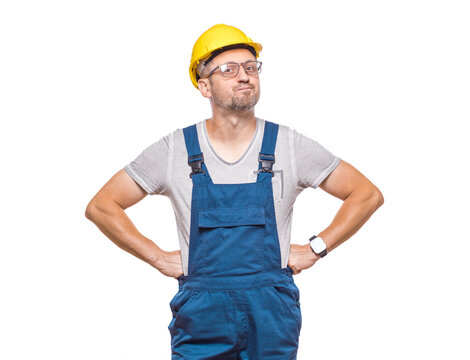Full length body of angry middle-aged construction worker with hands on waist looking to camera, isolated on white background. Displeased male builder stare to you. Craftsman against white wall