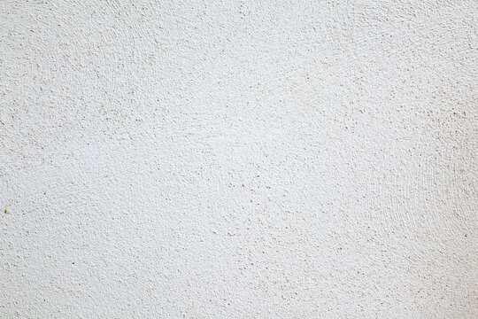 Superficie de pared blanca con textura de estuco.Primer plano de una pared blanca con textura fina de estuco y peque&ntilde;as irregularidades. Fondo minimalista ideal para arquitectura, dise&ntilde;o interior
