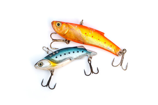 Pair of weathered vintage fishing lures with scratches and rusty treble hooks isolated on white background. Angling equipment showing signs of heavy use and weathering from successful fishing trips.