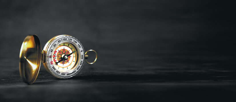 a closeup of a compass on a black background