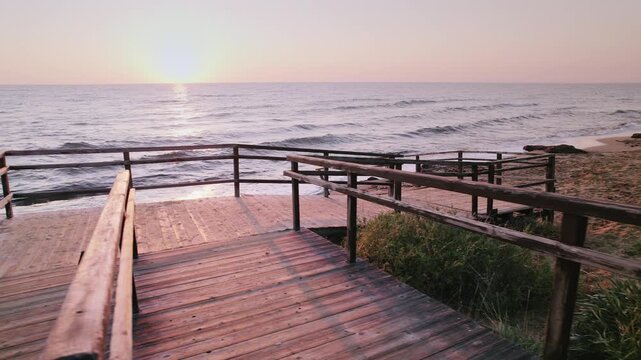 Old Wooden Steps on Long Beach at Sunrise: Waves Embracing the Sandy Shore in Iskele, Northern Cyprus