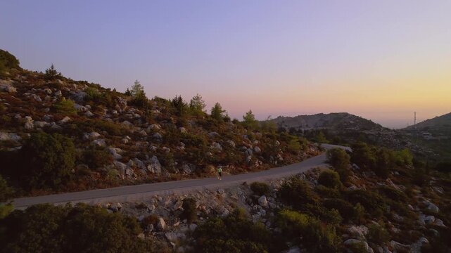 Plus Size Lady Running Along Countryside Road at Golden Hour Losing Weight and Burning Fat, drone view