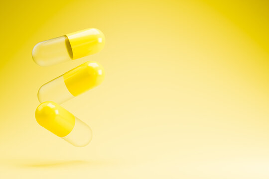 Yellow medical capsules falling on bright background