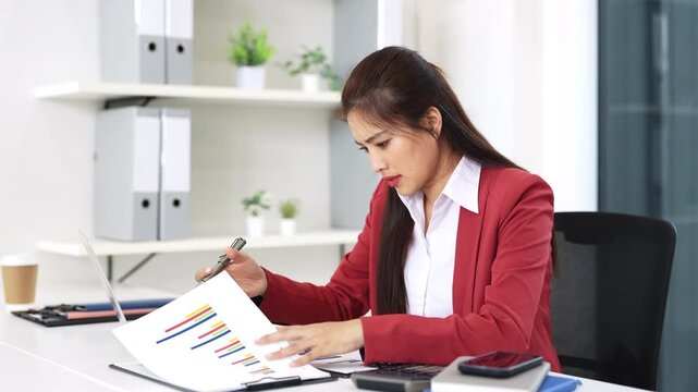 Asian business woman feeling stress and tired from work sitting on the chair about constant headaches a migraine of working hard at office.