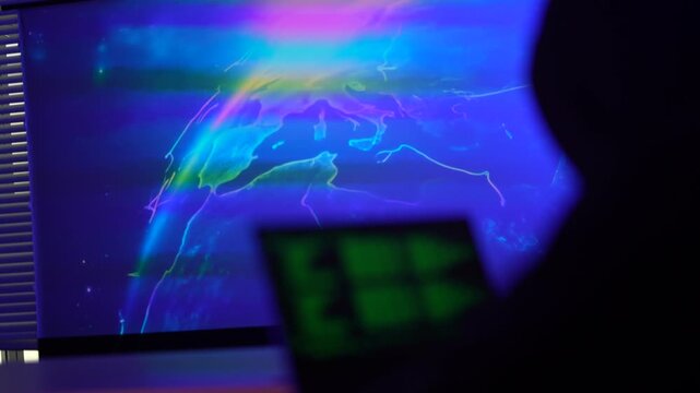 Anonymous cybercriminal exploiting system vulnerabilities in dark environment. Malicious hacker writing ransomware script to initiate corporate data breach on laptop network.