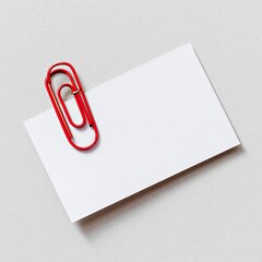 A blank white rectangle card secured by a vibrant red paper clip. Close-up, simple design