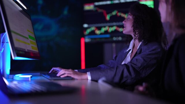Female fintech data scientists analyzing real-time cryptocurrency market volatility charts. Quantitative analysts developing high-frequency algorithmic trading strategies on multi-screen dashboard set