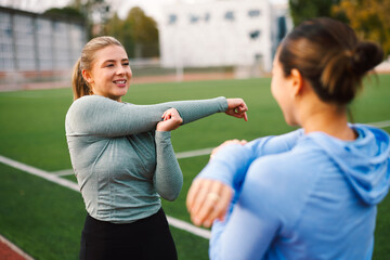 Female friends warming up together before training session